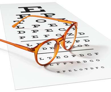 Orange eyeglasses on visual test chart isolated on white. Eyesight concept